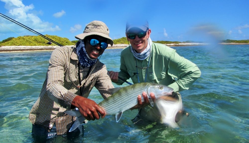 Angler and local guide holding a bonefish on the shallow flats near Anegada in the British Virgin Islands