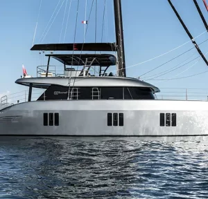 Side profile of SERENITY 60 Sunreef catamaran sailing in calm waters