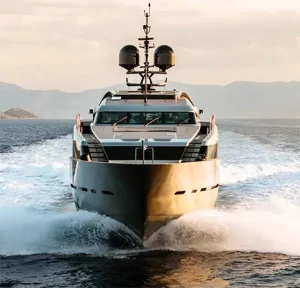 Motor Yacht NAIA cutting through the water with dramatic presence from the bow.