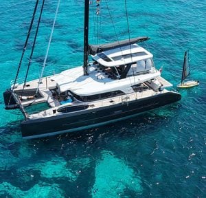 Aerial view of Lucky You Lagoon Sixty5 catamaran in turquoise waters of Italy.