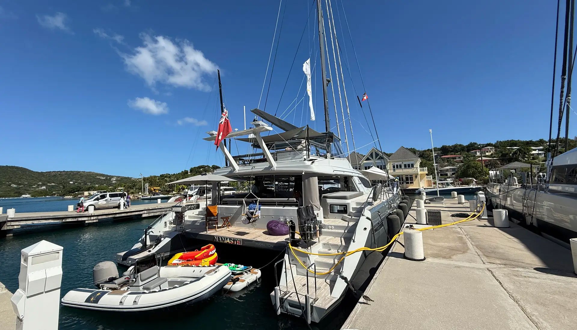 Luxury catamaran docked with tender and water toys prepared for charter in the Caribbean.