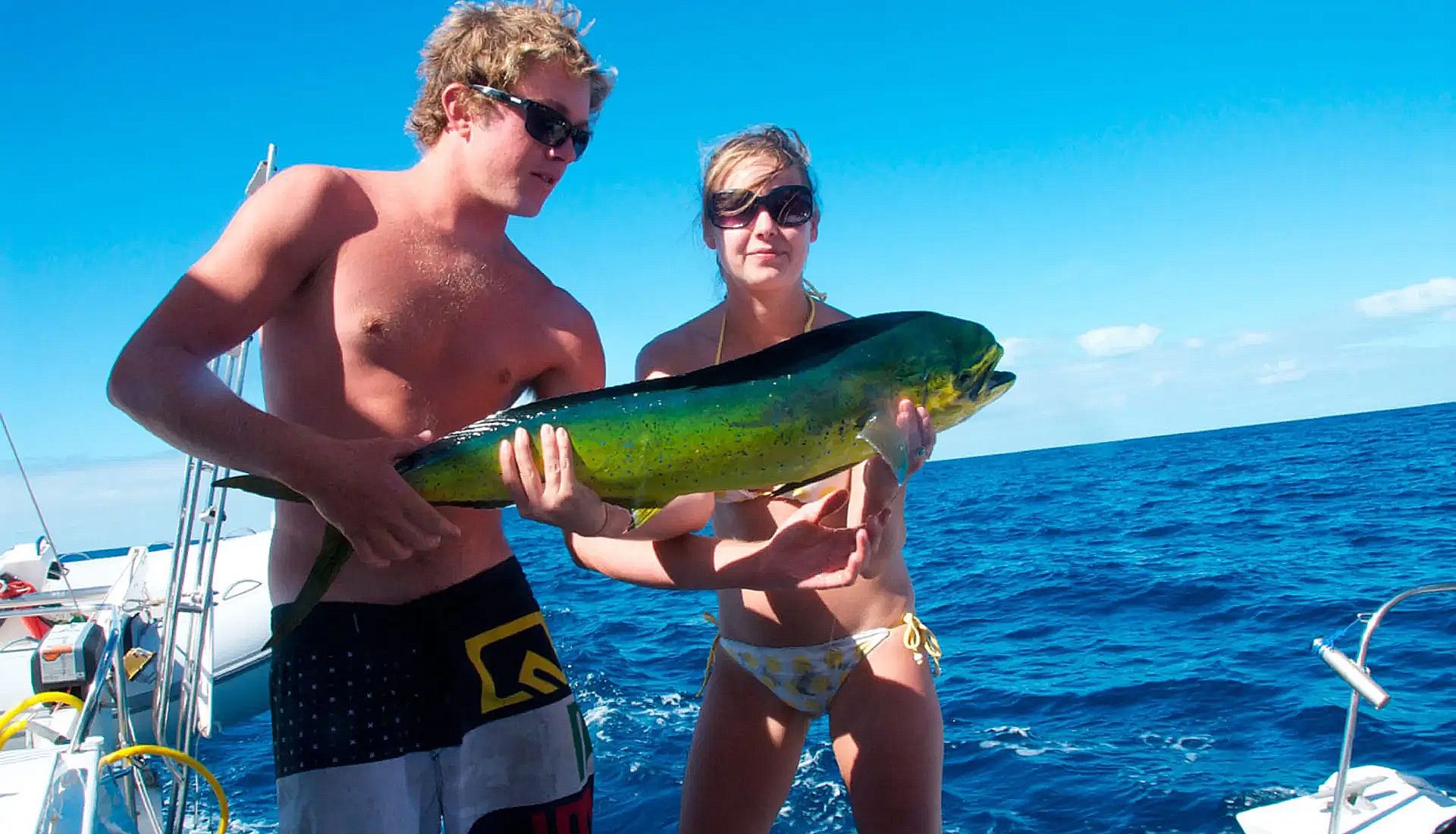 Guests holding a freshly caught mahi mahi on a BVI yacht fishing charter.