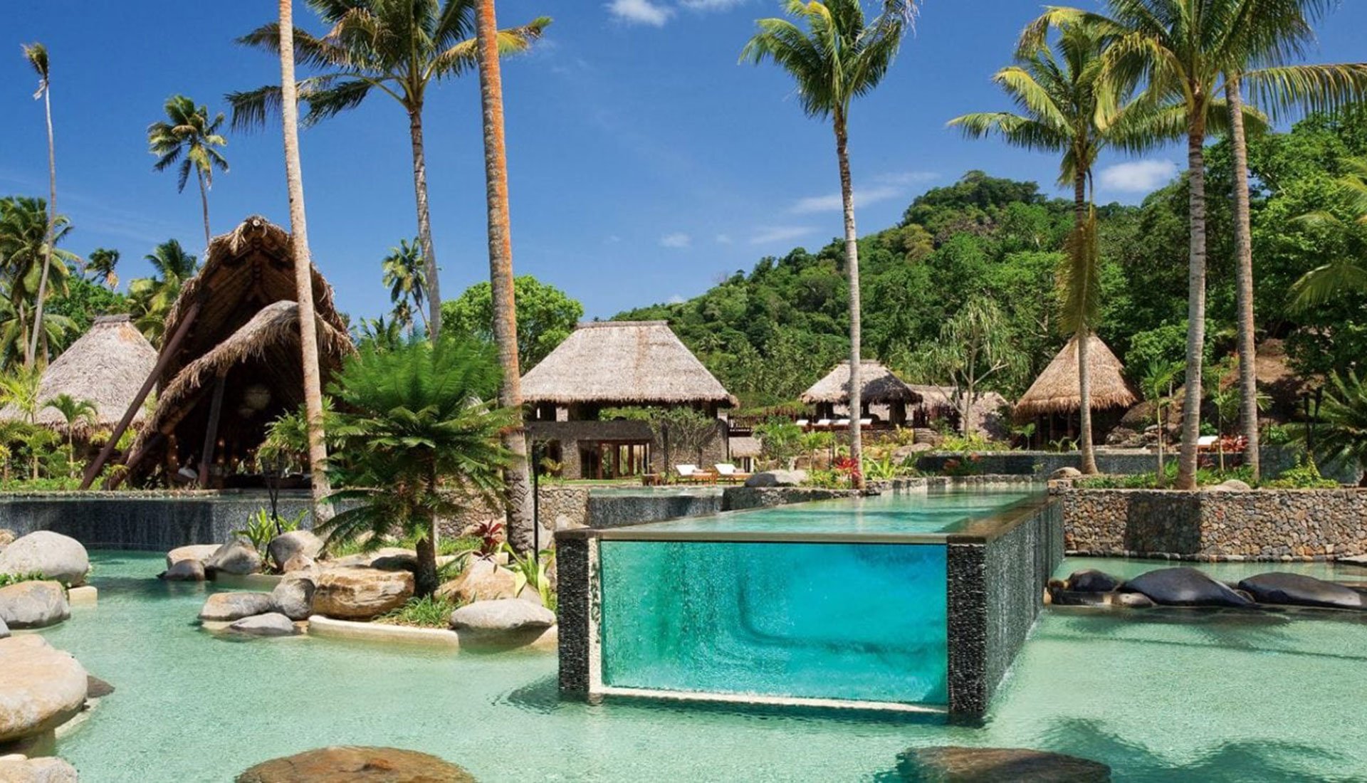 Luxury waterfront resort with pool and tropical villas, representing alternative accommodation options before or after a yacht charter.