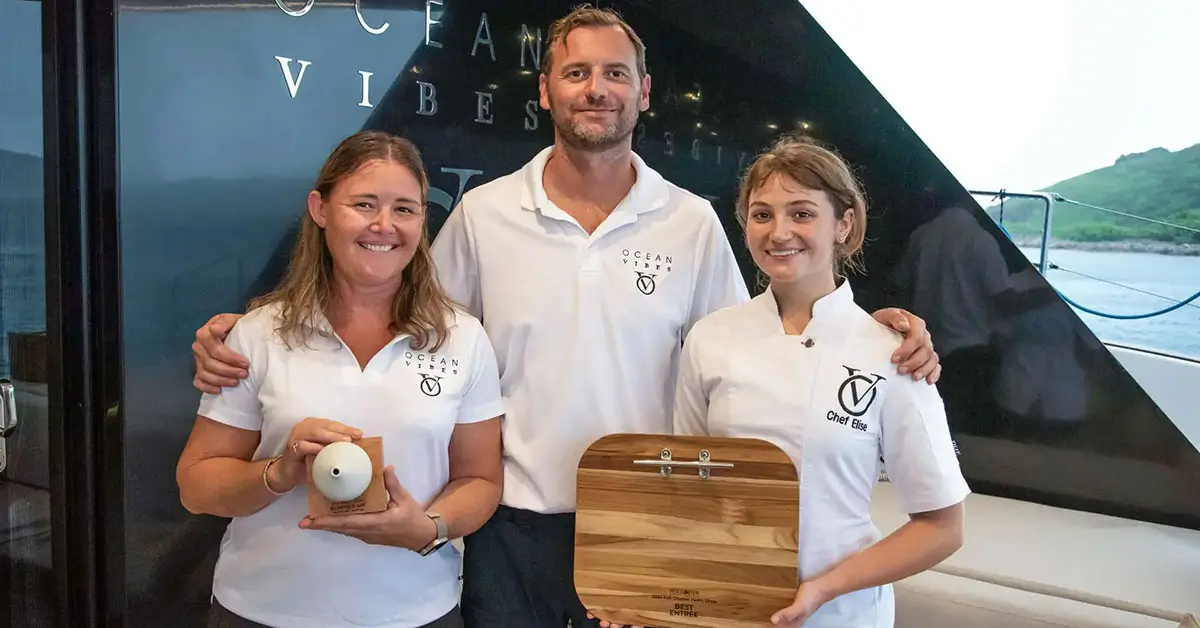 Yacht crew smiling onboard luxury catamaran, representing gratuity guidelines for Caribbean and Mediterranean yacht charters