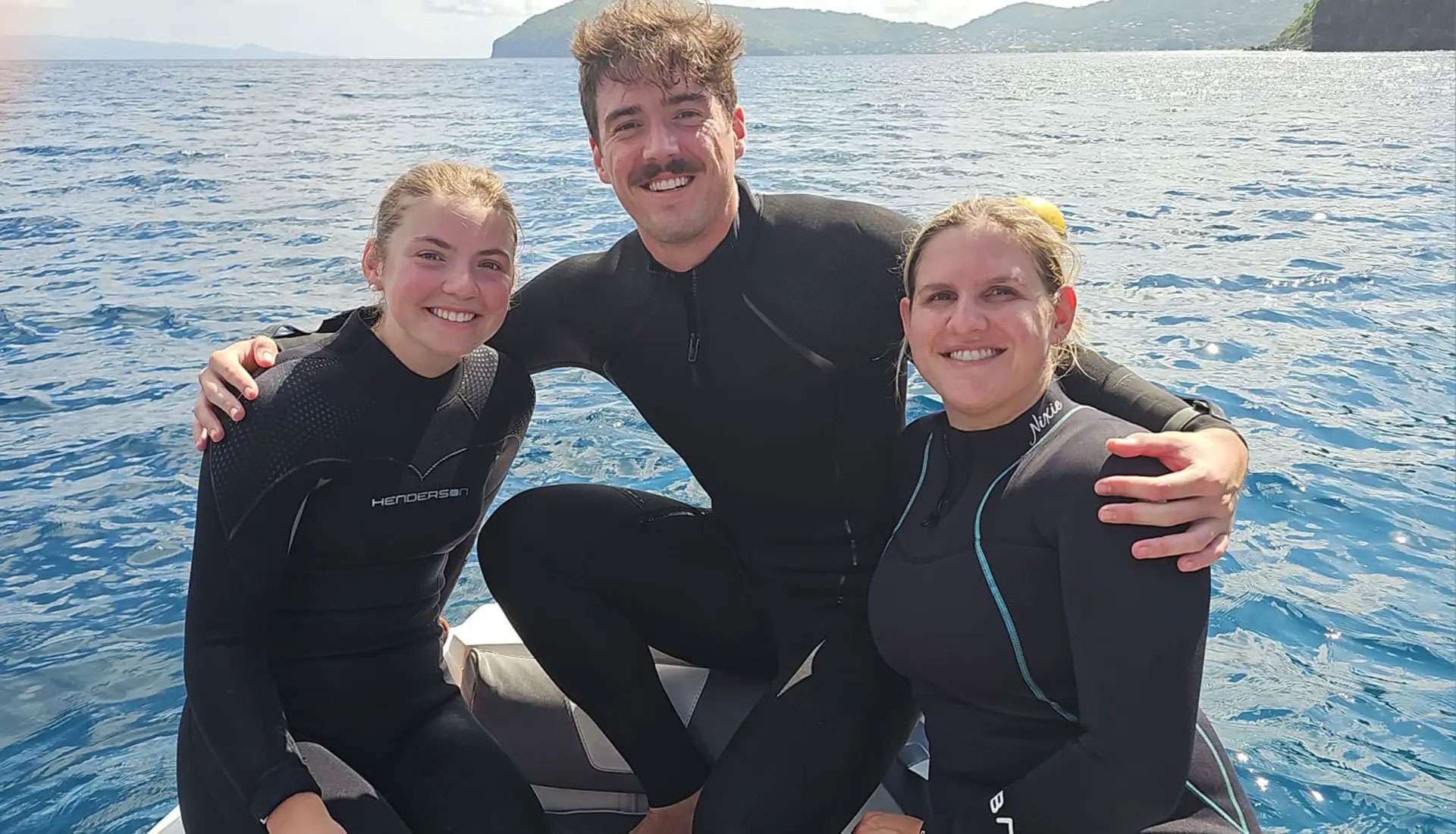 Guests in wetsuits preparing for a SCUBA certification dive during their yacht charter.