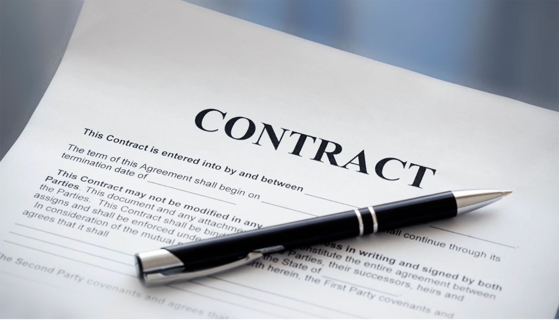 Yacht charter contract document with black pen on desk.