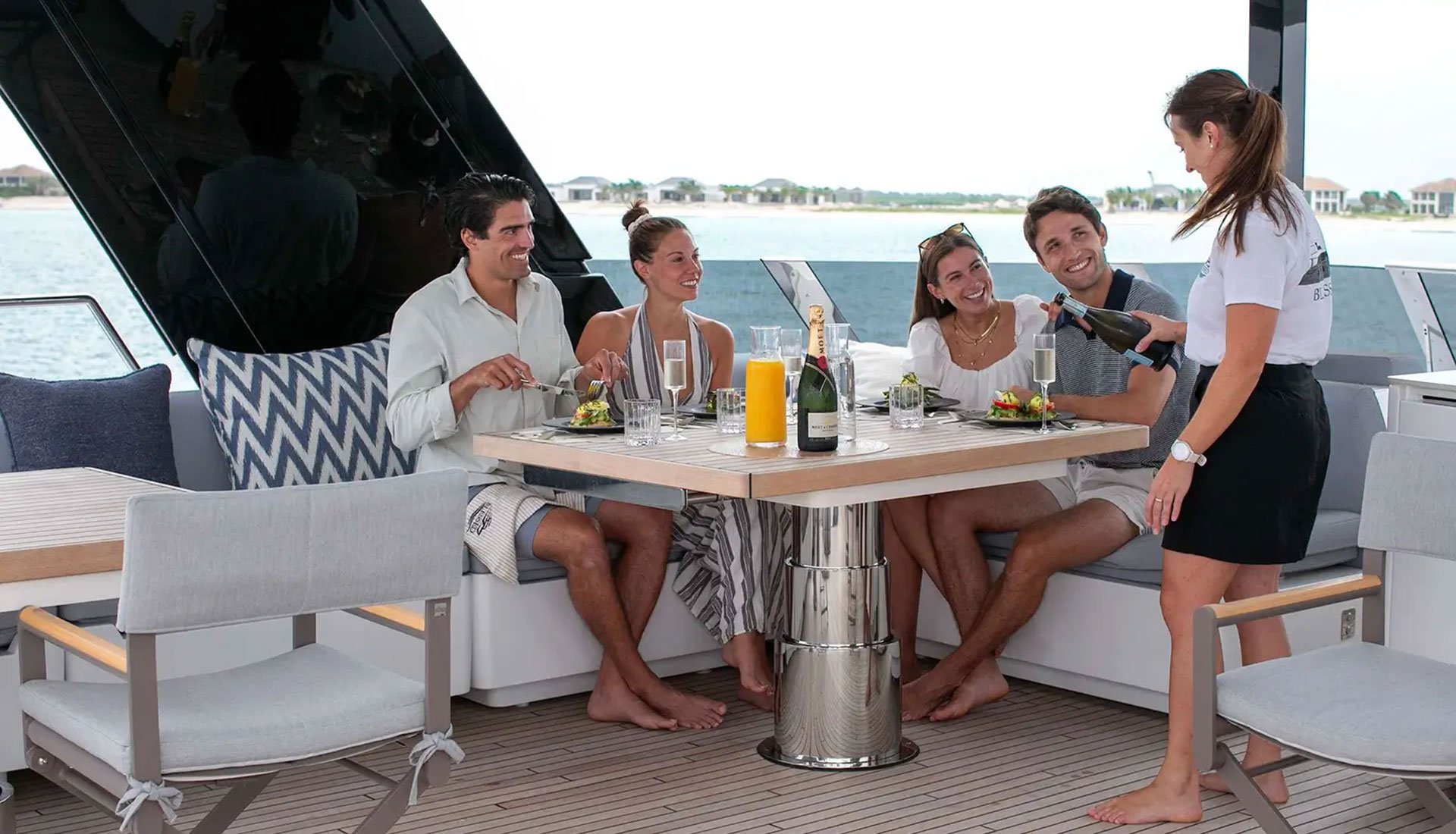 Guests enjoying dinner service aboard a luxury catamaran yacht.