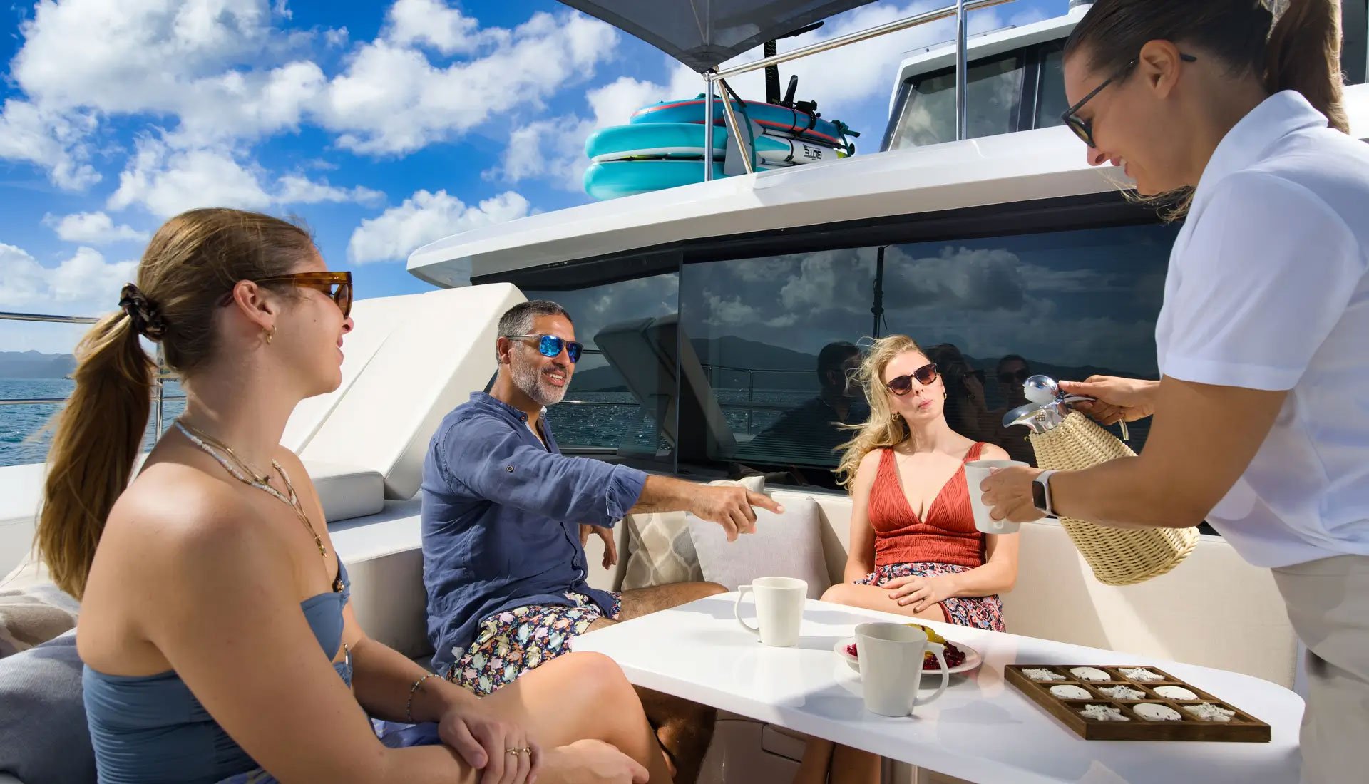 Guests being served coffee and pastries on deck during a half board yacht charter.