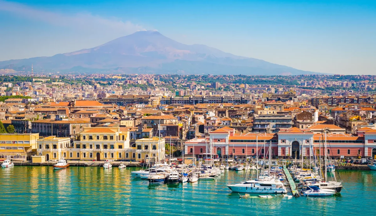 Catania marina with luxury yachts and Mount Etna volcano backdrop Sicily