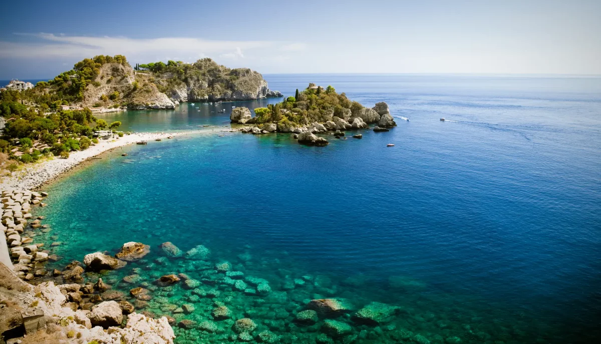 Aerial view of Isola Bella nature reserve in Taormina with turquoise waters and yacht anchorage