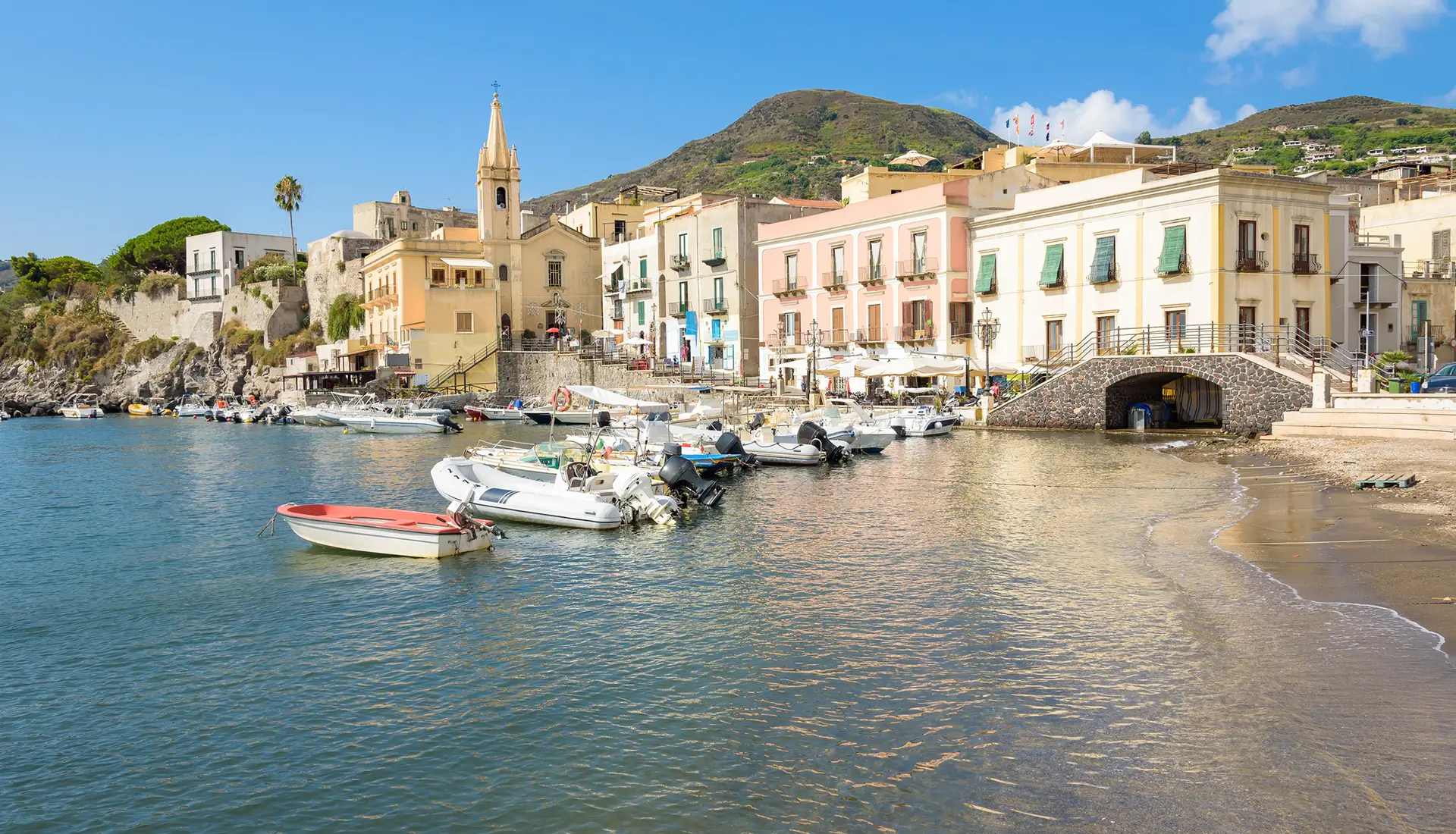Marina Corta harbor in Lipari with colorful Italian buildings and traditional fishing boats