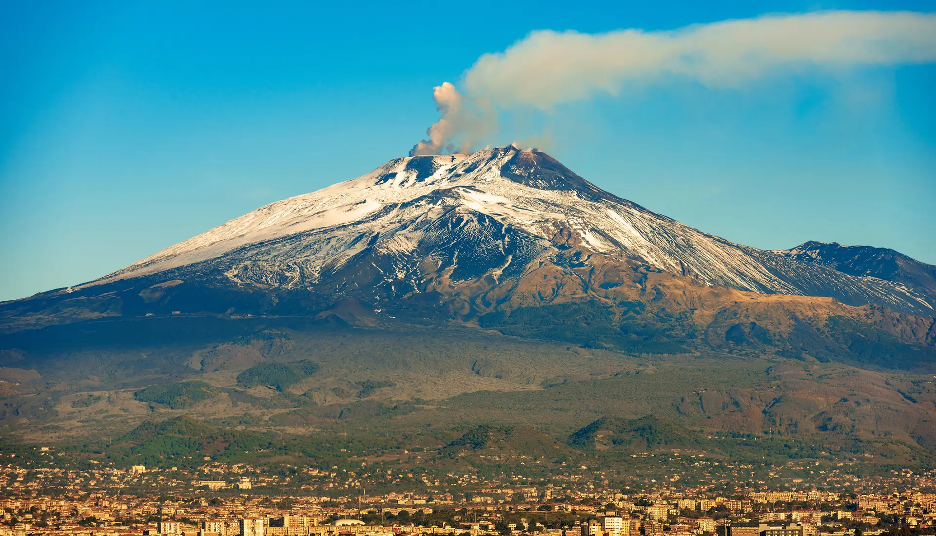 Mount Etna silhouette at sunset viewed from the sea approaching Catania