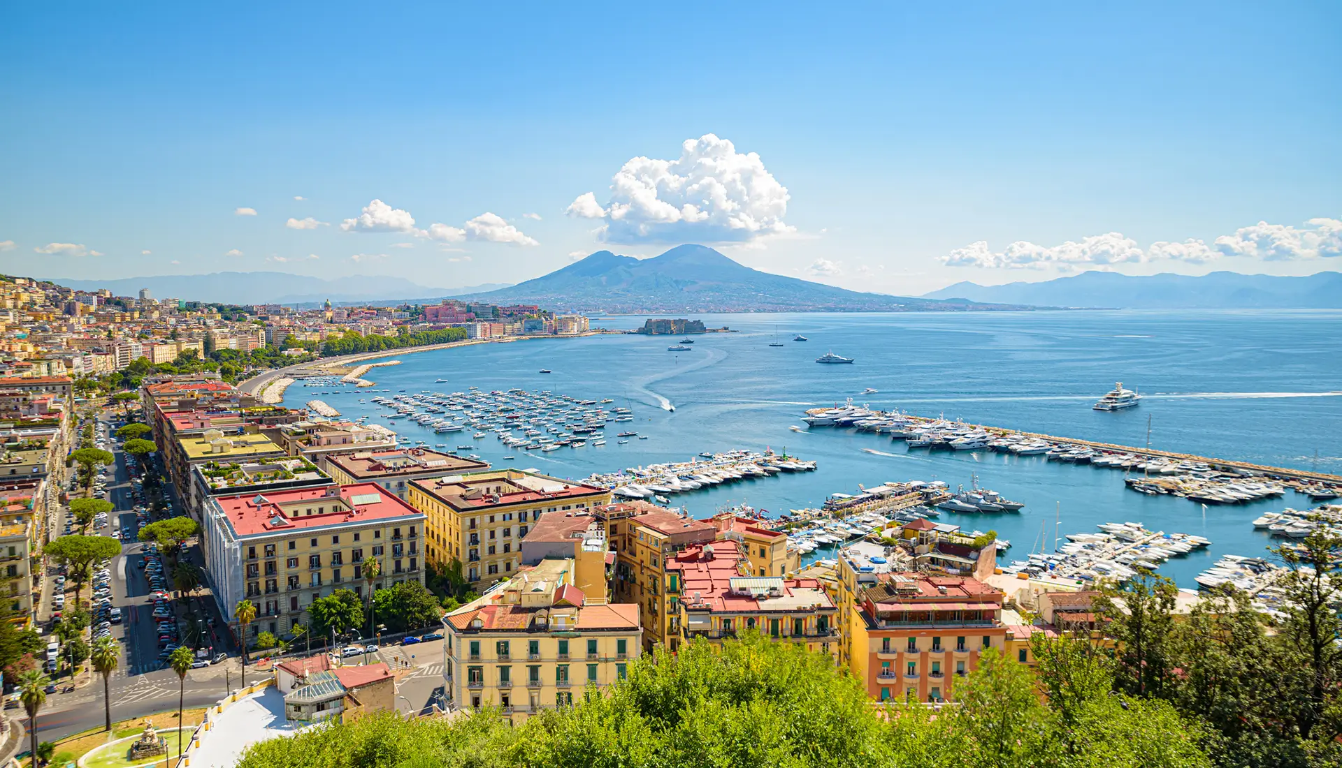 Naples harbor and marina with Mount Vesuvius in the background, showing yachts and the city waterfront