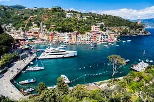 Portofino harbor with luxury superyacht moored among colorful Italian Riviera buildings