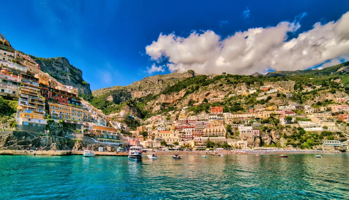Positano colorful houses cascading down clifftop as seen from approaching yacht on Amalfi Coast