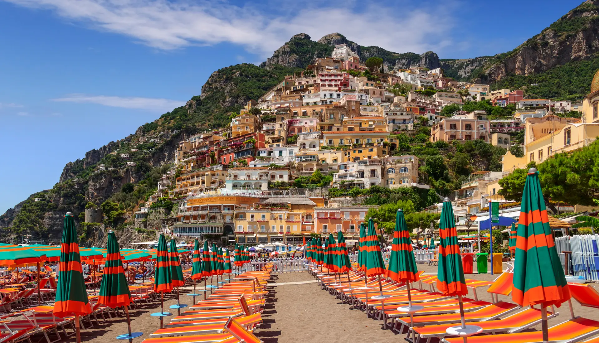 Positano's Spiaggia Grande beach with orange umbrellas and colorful houses on hillside
