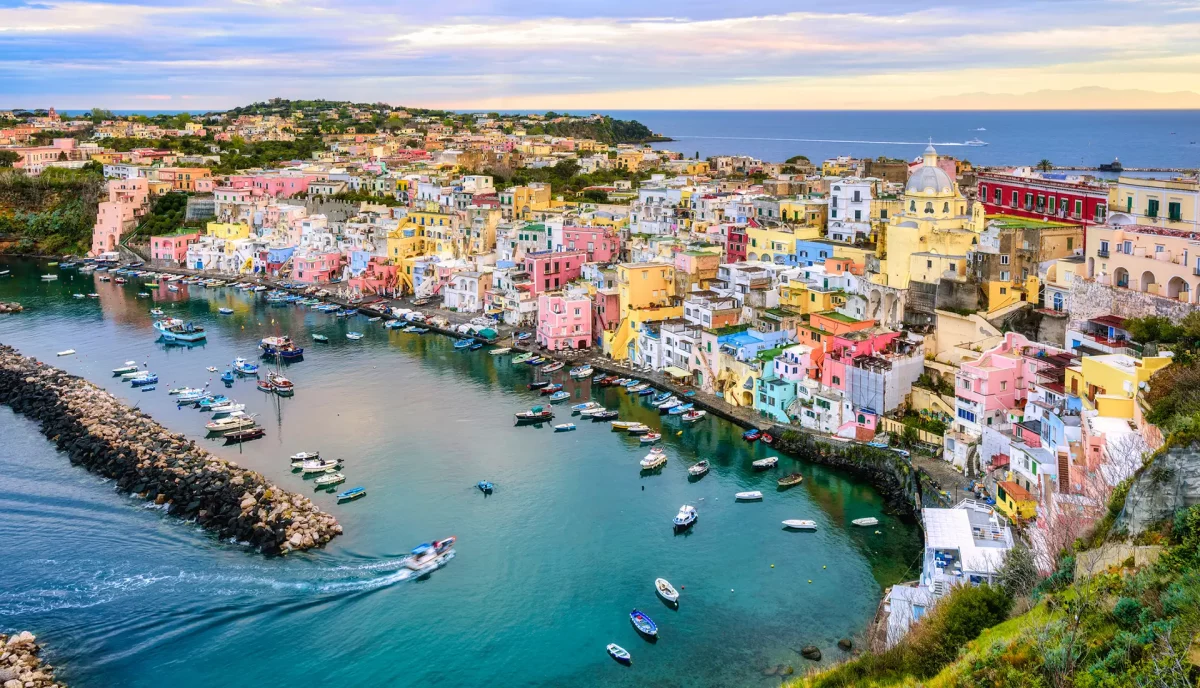 Procida's Marina Corricella colorful fishing village with pastel houses stacked along waterfront