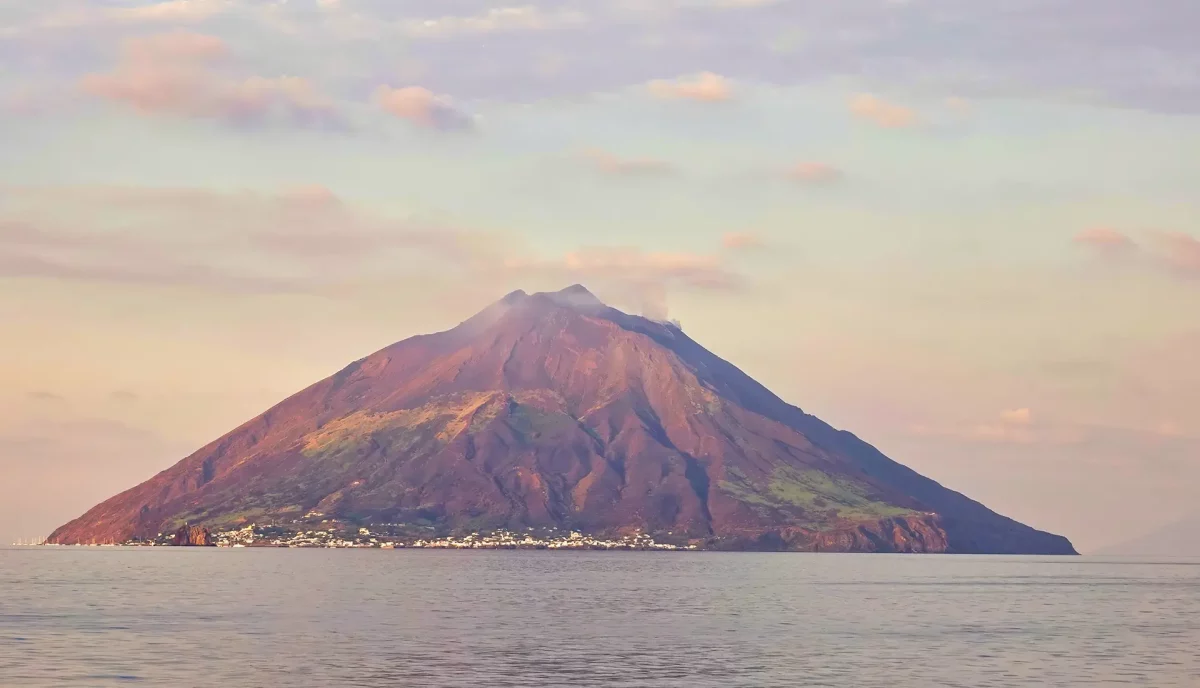 Stromboli volcano at sunrise showing perfect cone shape rising from Mediterranean Sea