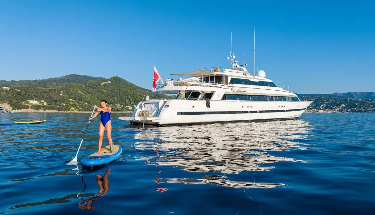 Caribbean yacht charter activities with paddleboarding and luxury motor yacht