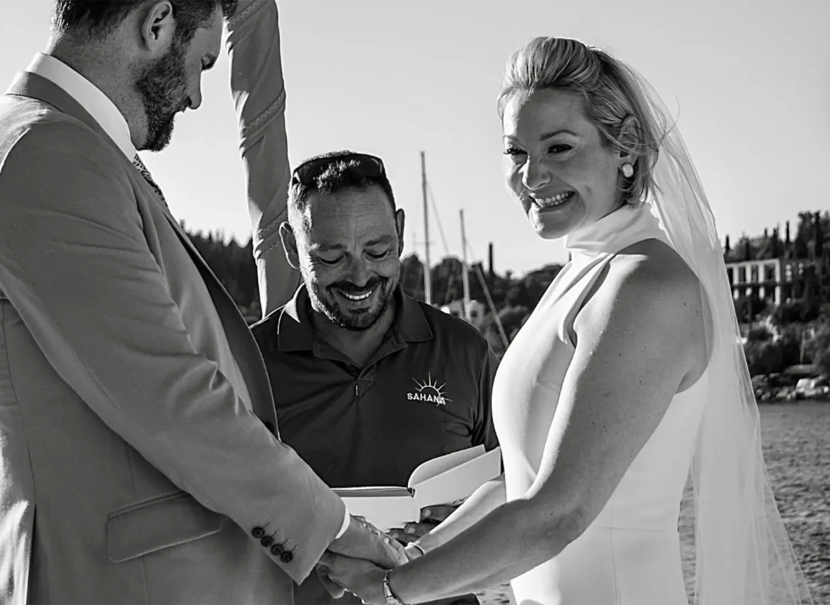Professional yacht captain performing intimate wedding ceremony aboard luxury charter yacht in Greece