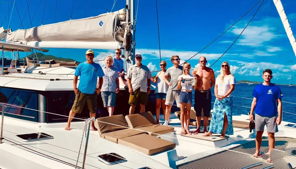 Large group of diverse travelers together on catamaran deck during cabin charter vacation