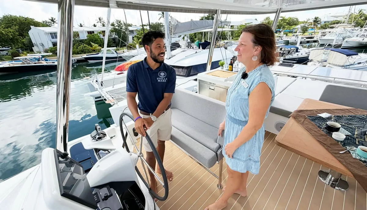 Yacht broker having conversation with charter catamaran captain on deck
