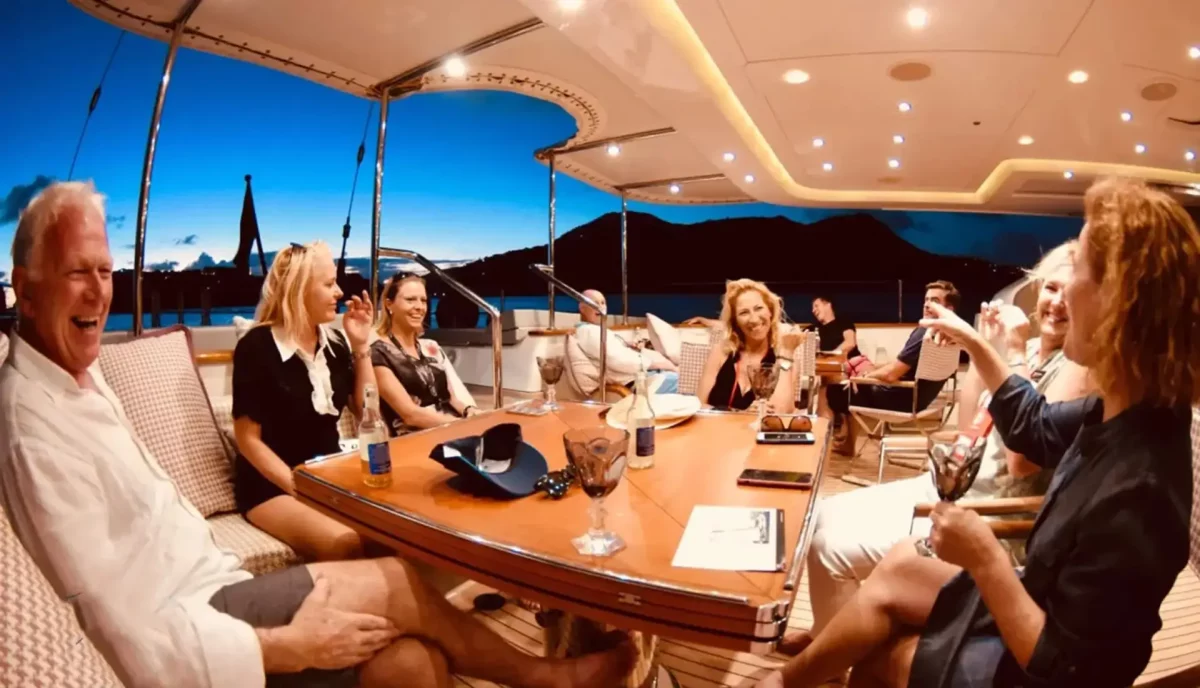 Guest enjoying yacht charter deck dining area with comfortable seating and ocean views