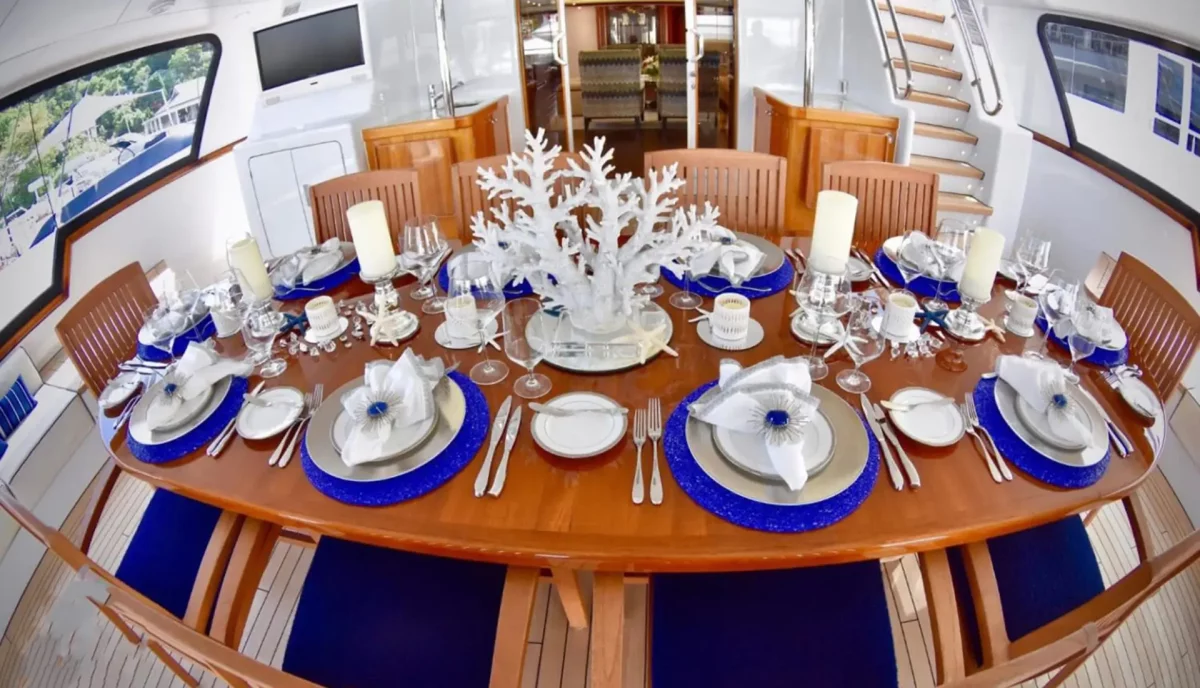 Elegant formal dining table setup aboard luxury yacht with fine china and crystal