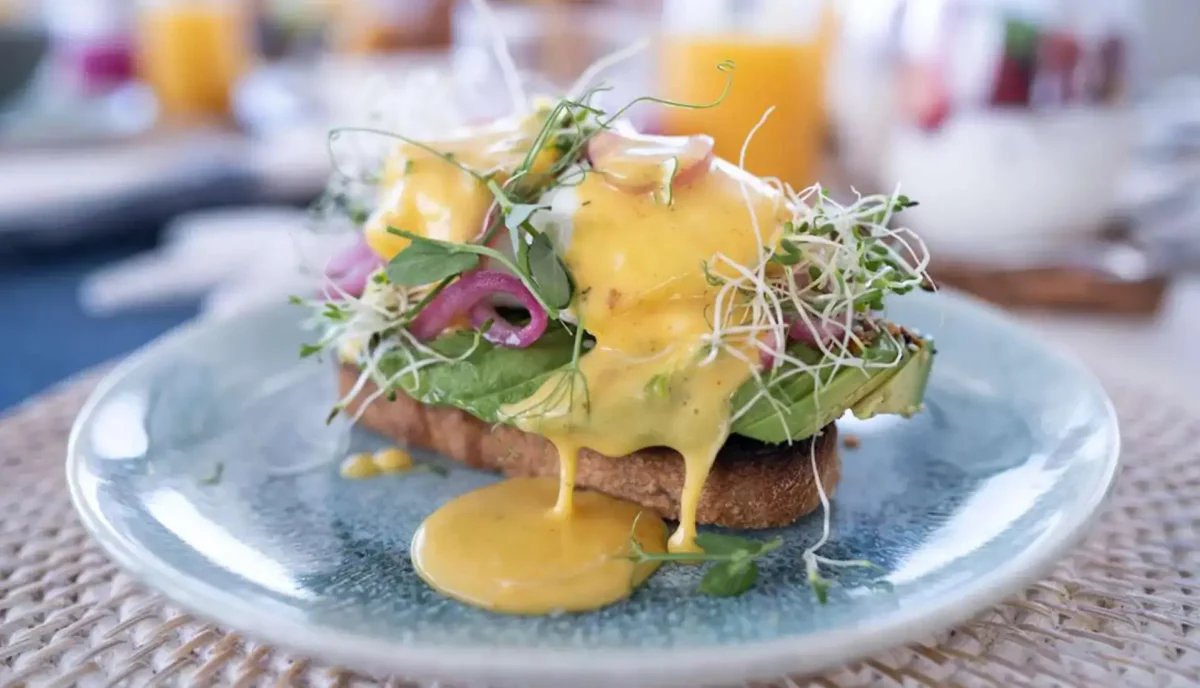 Gourmet eggs Benedict breakfast prepared by yacht charter chef with hollandaise and microgreens