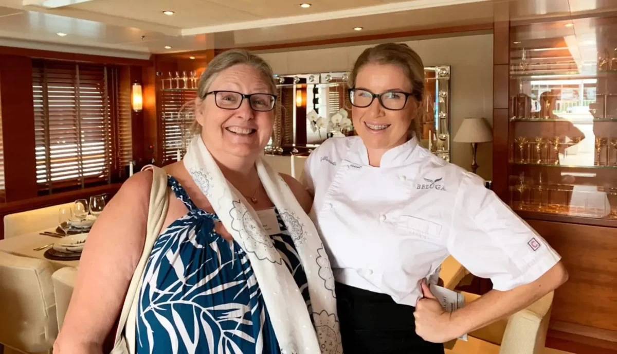 Yacht charter guest with professional chef in yacht galley discussing meal preferences