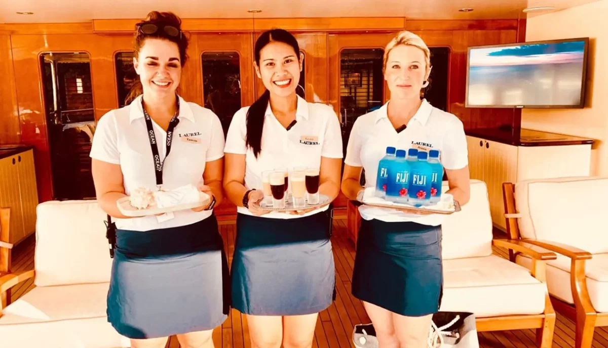 Professional yacht crew serving refreshments and providing attentive hospitality service