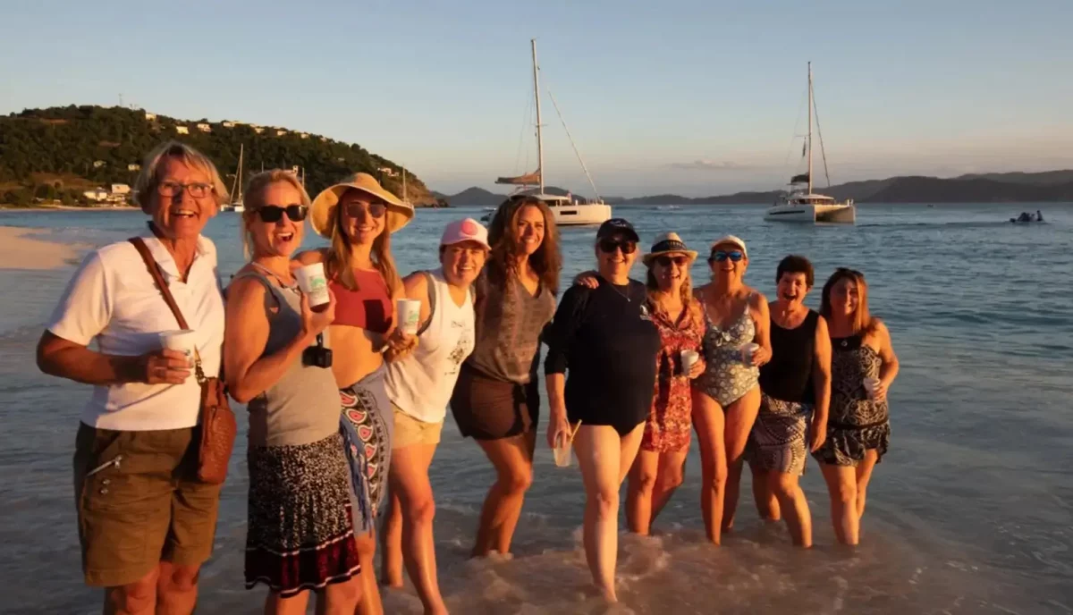 Happy charter yacht guests on the beach at White Bay, Jost Van Dyke, British Virgin Islands at sunset