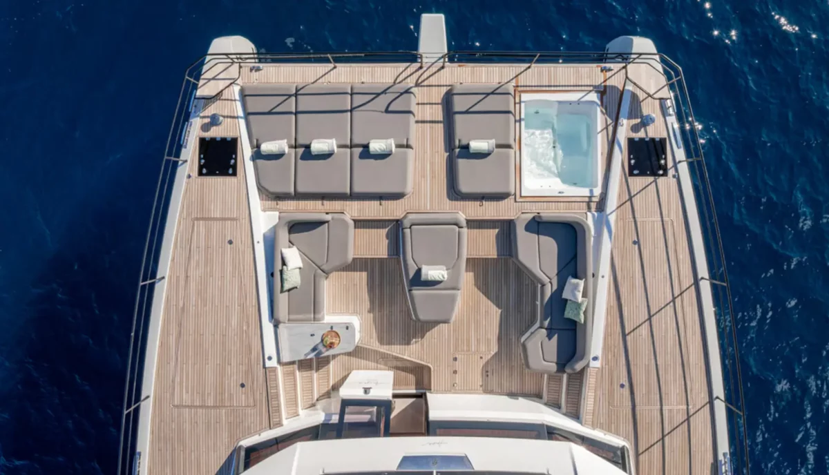 Aerial view of Anima catamaran foredeck showing Jacuzzi sun loungers and teak deck layout