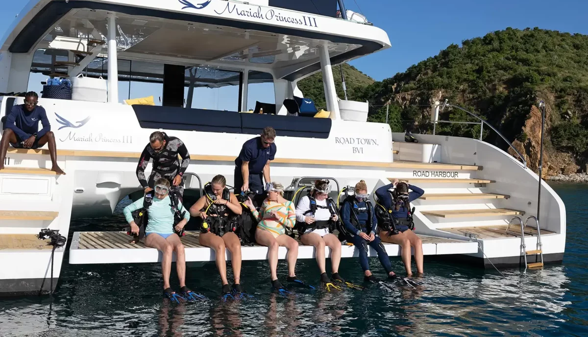 Group of scuba divers in full gear on the stern of a catamaran in Road Town BVI