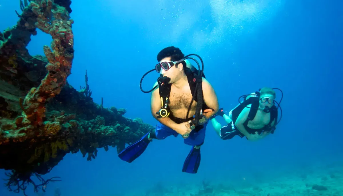 Two scuba divers exploring the deep section of the RMS Rhone wreck in the British Virgin Islands