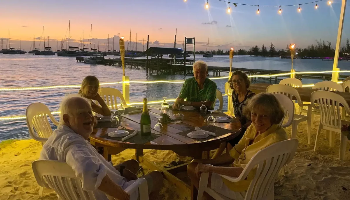 Charter guests enjoying lobster dinner at the Anegada Reef Hotel BVI at golden hour under string lights