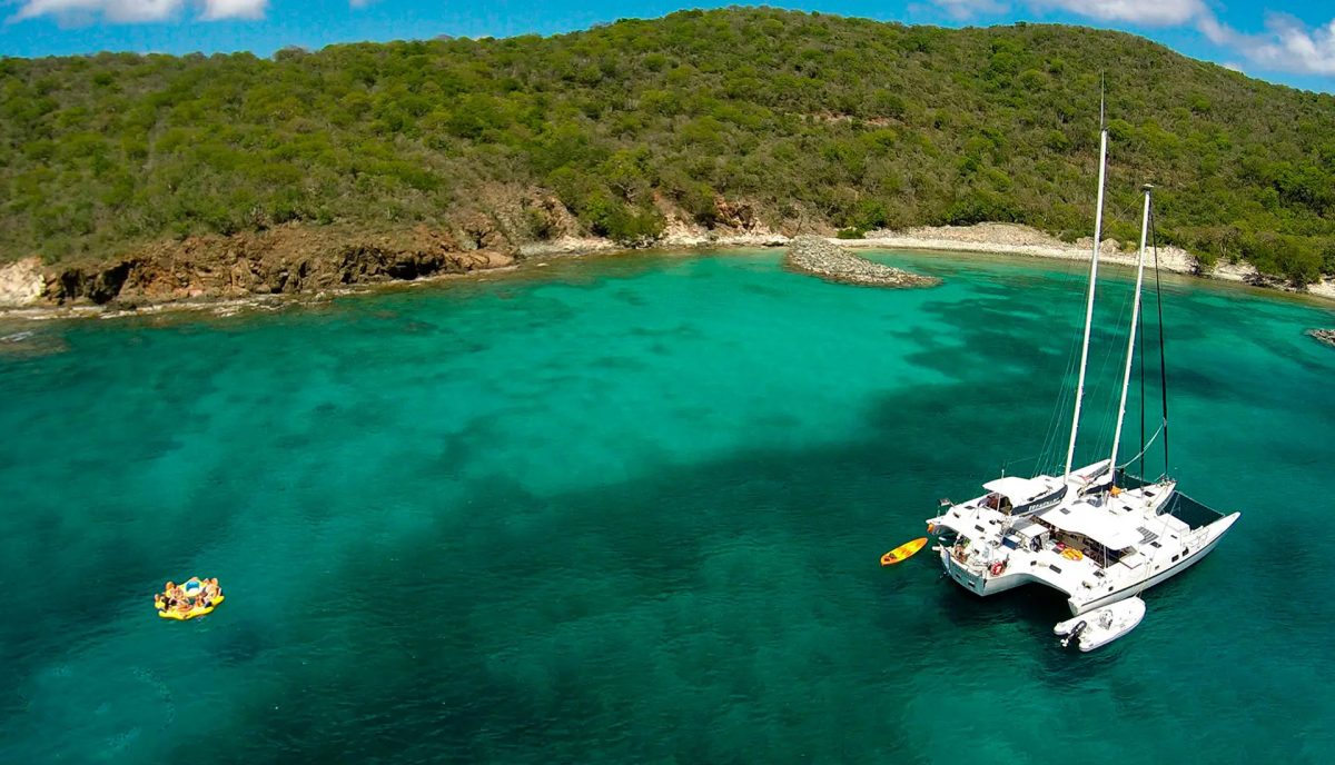 Catamaran anchored in the turquoise water of Money Bay on the south side of Norman Island BVI