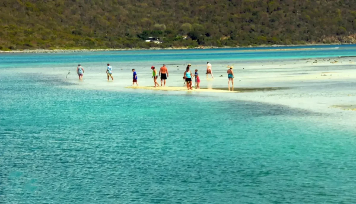 Guests walking on the shallow reef at Beef Bluff at low tide, Beef Island, Tortola BVI