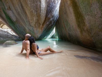 couple in a cave at The Baths, Virgin Gorda, BVI honeymoon couple relaxing in a cave at The Baths, Virgin Gorda, British Virgin Islands