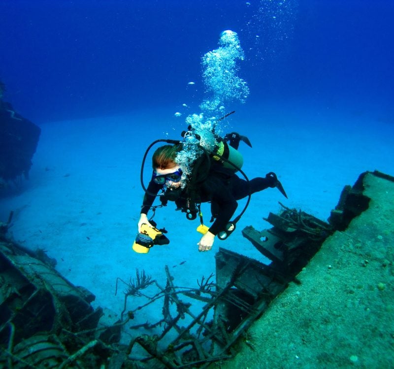 Diver photographing a Sunken Shipwreck Diver photographing a Sunken Shipwreck in Cayman Brac